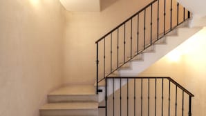 A staircase with a black metal railing and beige walls. - San Moisé (Venice)