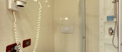 A bathroom with a hairdryer, a shower, and a towel rack.