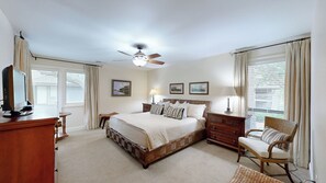 A bedroom with a bed, a desk, a chair, a ceiling fan, and a window with curtains. - Fully renovated condo with views of the 11 mile lagoon system! (Hilton Head)