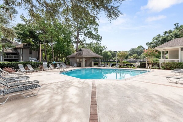 A swimming pool with lounge chairs and a gazebo. - Fully renovated condo with views of the 11 mile lagoon system! (Hilton Head)