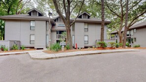 A row of two-story apartment buildings with a uniform exterior design, featuring a flat roof and a small balcony on each unit. - Fully renovated condo with views of the 11 mile lagoon system! (Hilton Head)