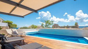 A wooden deck with lounge chairs and a swimming pool. - Villa Valentina (Bol)