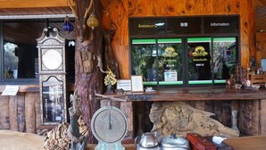 A wooden interior with a reception desk, a clock, and various decorative items. - Denchai City Resort (Den Chai)