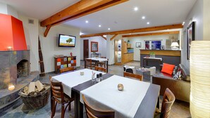 A spacious living area with a fireplace, dining table, and seating arrangements.