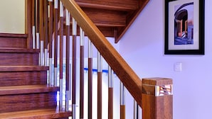 A wooden staircase with a handrail and a picture frame on the wall.