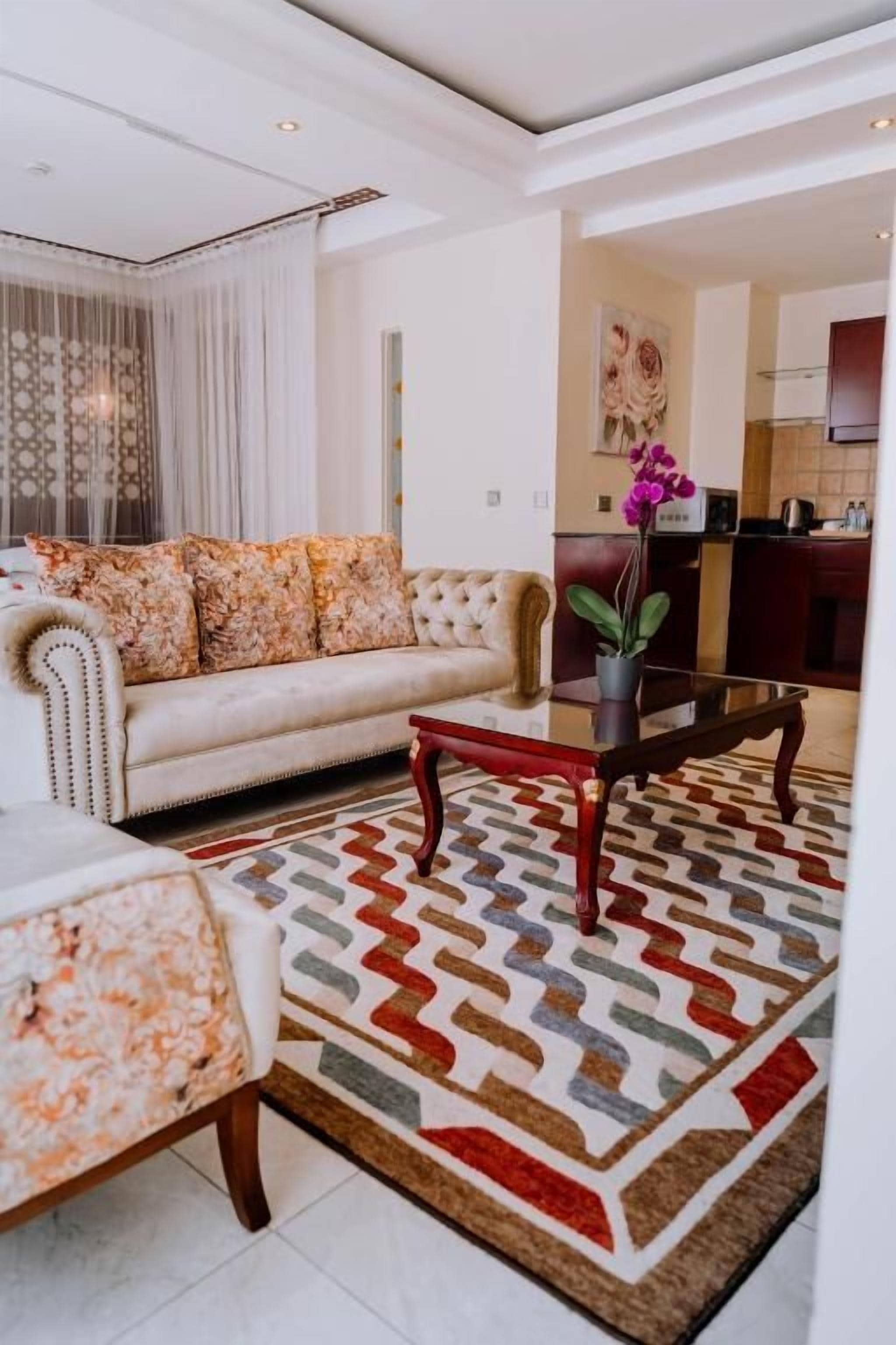 A living room with a sofa, a coffee table, and a patterned rug.