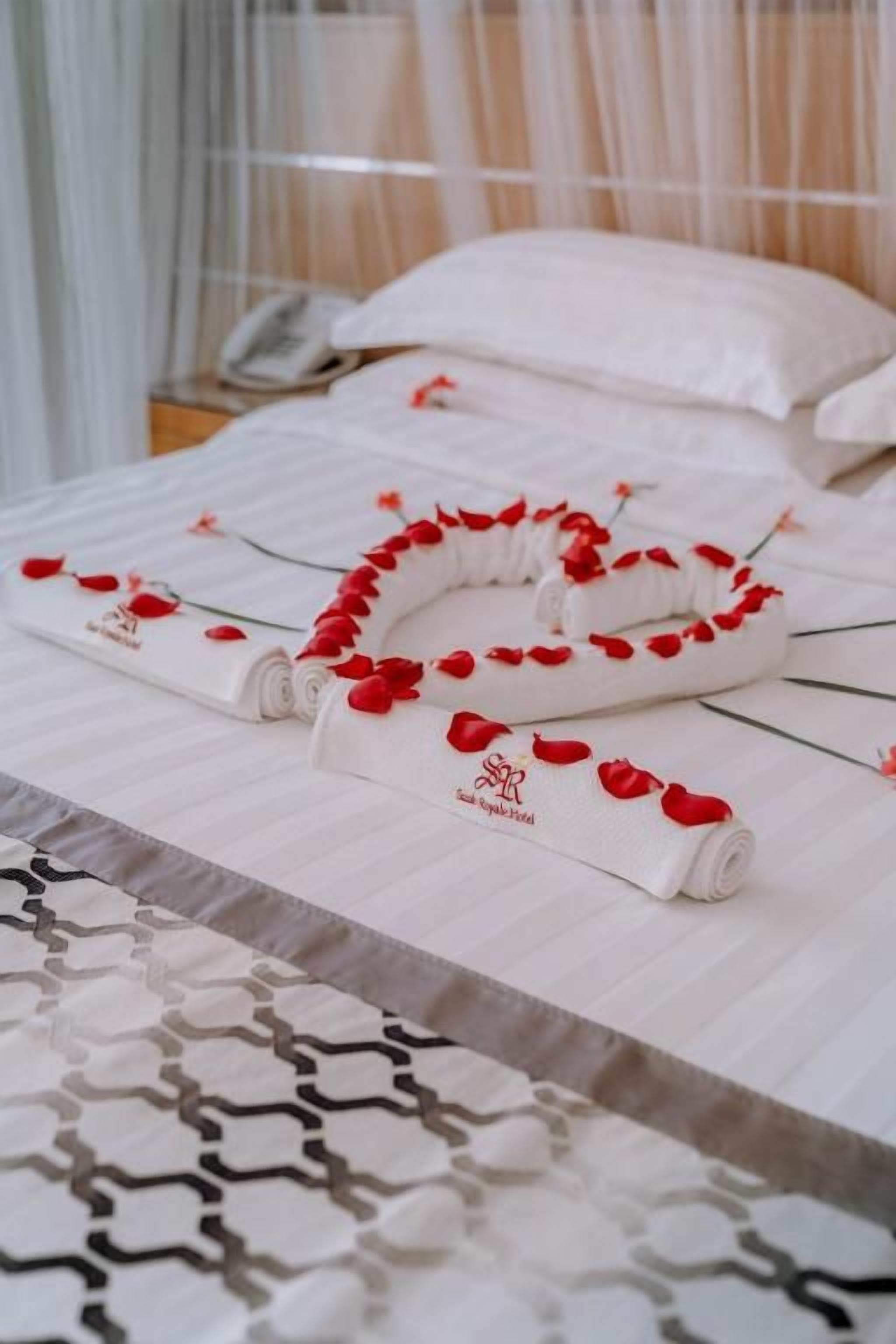 Una cama bien hecha con una toalla y un adorno.
