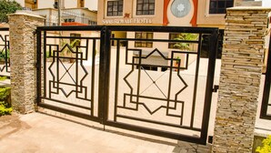 A gated entrance to the Saab Royale Hotel with a stone pillar and a geometric metal gate. - Saab Royale Hotel (Nairobi)