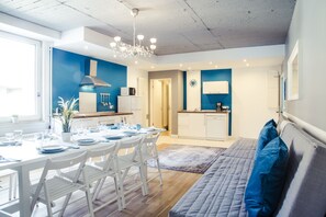 Una cocina moderna con armarios blancos, un microondas integrado y una campana extractora de acero inoxidable.