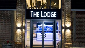 A hotel entrance with a prominent sign reading "THE LODGE". - The Lodge at Kingswood (Tadworth)