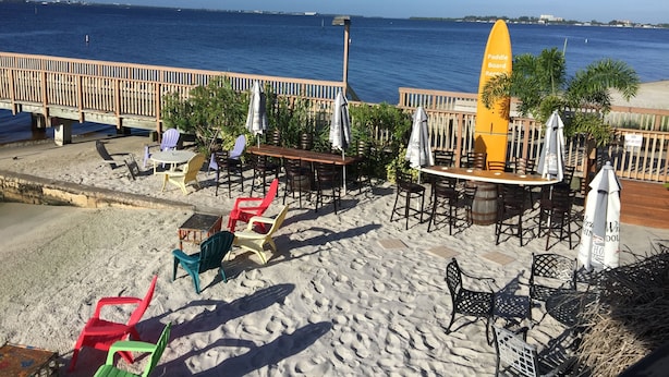 Ein Restaurant direkt am Strand mit Außenbereich, einer Holzterrasse und Meerblick.