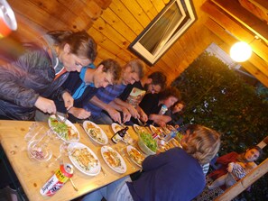 A group of people dining at a wooden table with various dishes and drinks. - Hotel Dirbach Plage (Esch-sur-Sure)