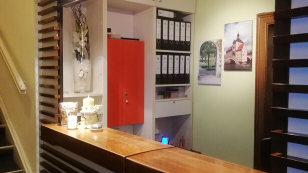 Een trap met een houten leuning en een balie met decoratieve objecten.