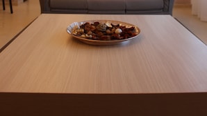 A modern living room with a sofa, a television, and a bowl of snacks on a table. - Miramare Scilla GYH Luxury (Scilla)