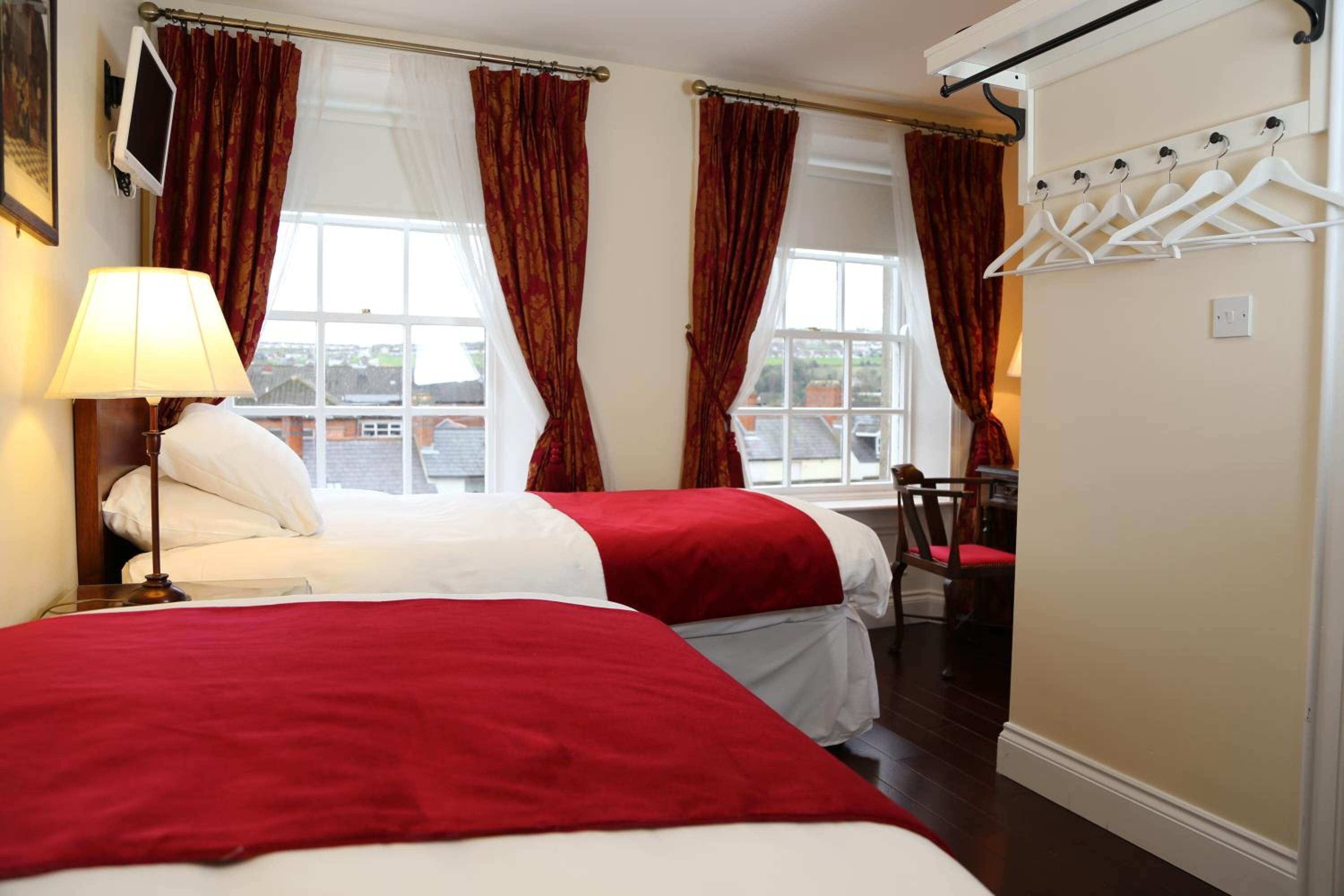 Ein Hotelzimmer mit zwei Betten, einem Schreibtisch und einem Stuhl.