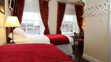 Ein Hotelzimmer mit zwei Betten, einem Schreibtisch und einem Stuhl.