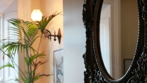 A room with a fireplace, a large ornate mirror, and a potted plant. - Number 8 The Townhouse (Londonderry)