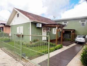 Un edificio residencial con fachada verde, techo de tejas y antena parabólica.
