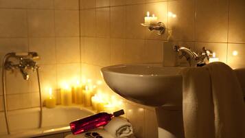 A bathroom with a bathtub, a sink, and a towel rack.