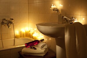 A bathroom with a bathtub, a sink, and a towel rack. - Agnantio studios & suites (Gortynia)