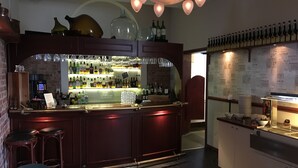 A bar area with a counter, stools, and a wine display.