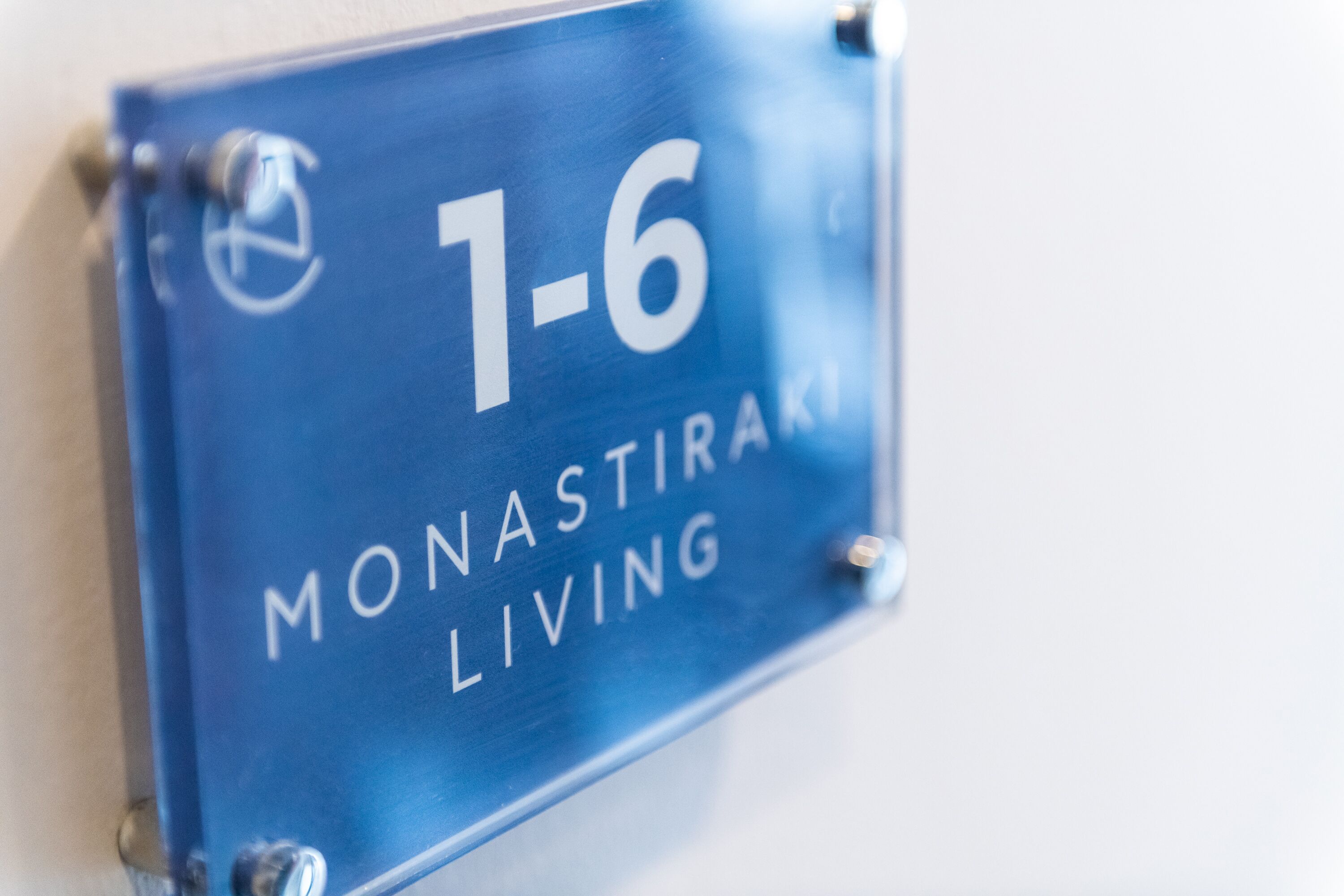 A blue sign with the number 1-6 and the words "MONASTIRAKI LIVING" on it.