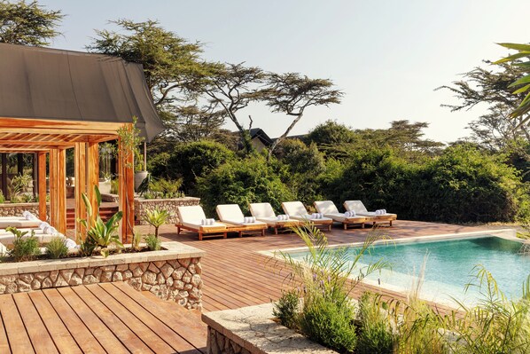 A wooden deck with lounge chairs and a pool. - JW Marriott Mount Kenya Rhino Reserve Safari Camp (Laikipia County)