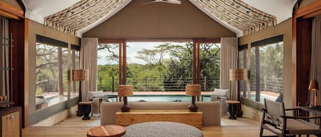 A modern interior with a pool view, wooden furniture, and a unique ceiling design.
