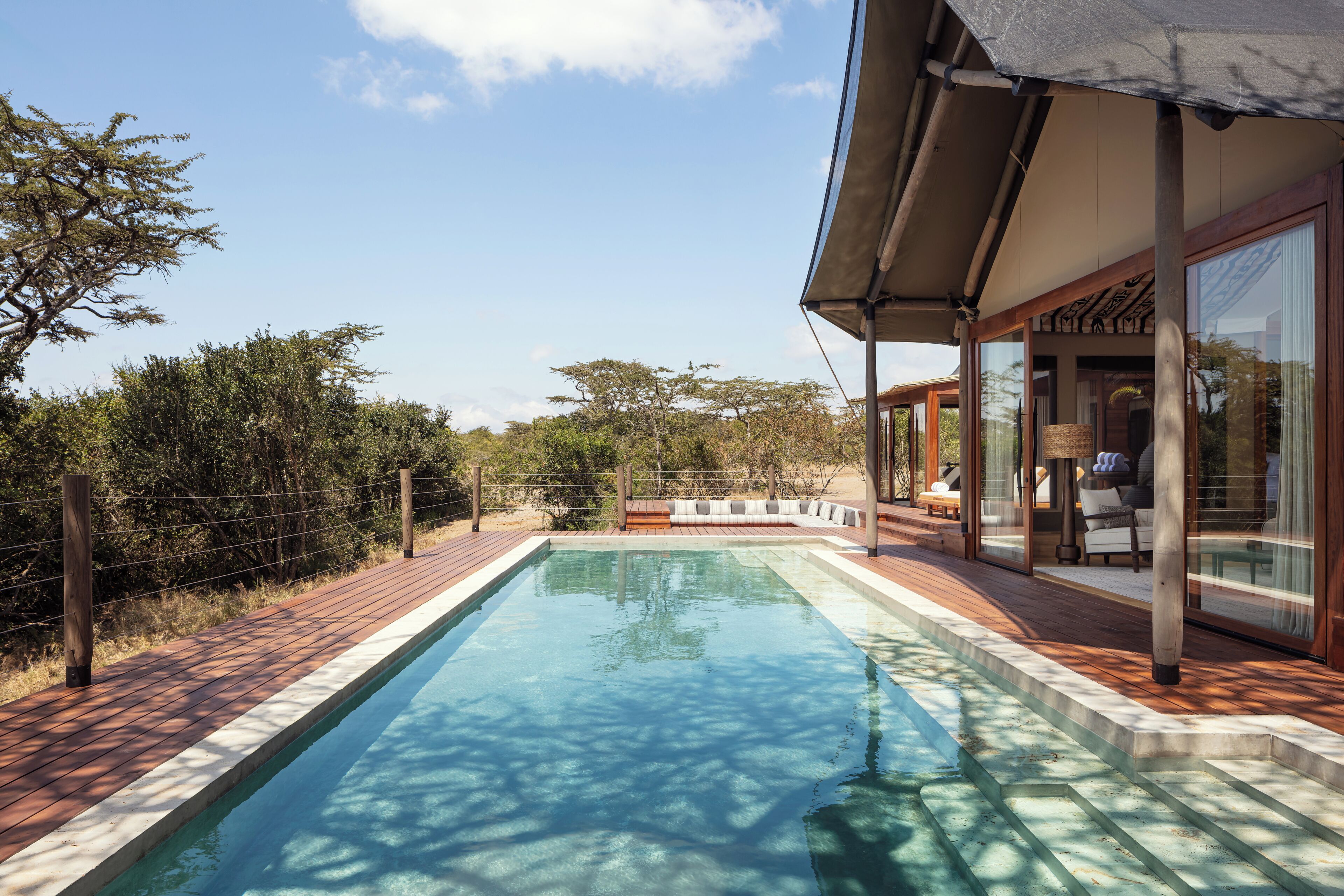Una piscina al aire libre, sillones reclinables de piscina