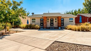 A modern building with a flat roof, a prominent address sign, and a well-maintained front yard with landscaping.