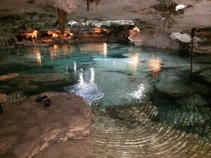 A cave with a clear pool, rocky formations, and a wooden structure. - Amazing Spacious Villa in the perfect location!  Steps to the Beach & Town! (Playa del Carmen)