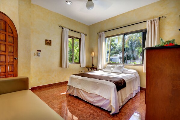 A bedroom with a bed, a desk, and a window with curtains. - Amazing Spacious Villa in the perfect location!  Steps to the Beach & Town! (Playa del Carmen)