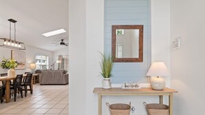 A modern interior with a dining area, a console table with baskets, a mirror, and a ceiling fan. - Indian Ridge - Pool Home Spa, Newly Renovated (Kissimmee)