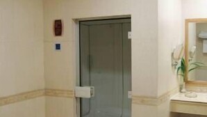 Un baño con cabina de ducha de vidrio, un lavamanos con espejo y un inodoro.
