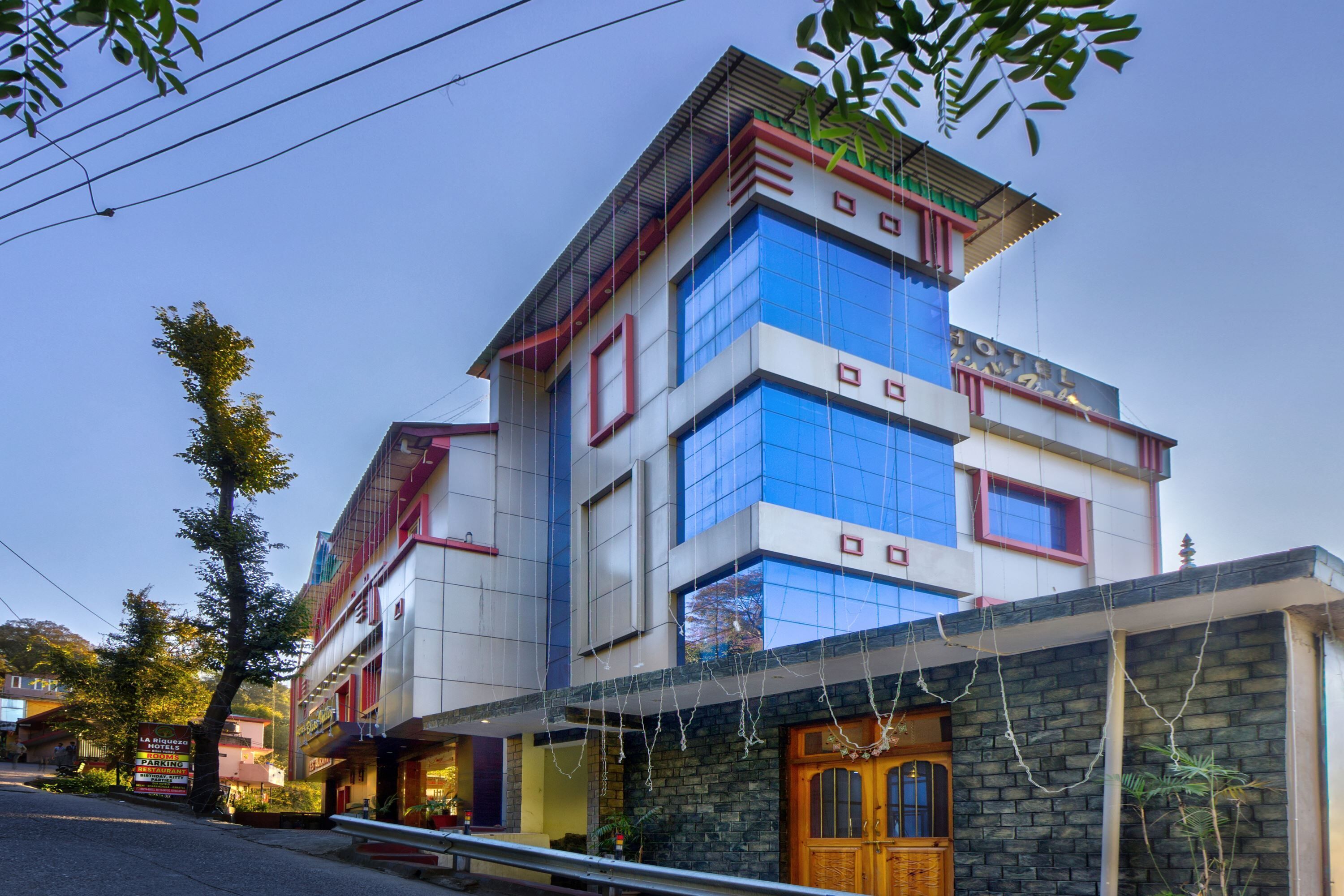 Um hotel com várias andares, fachada moderna, janelas amplas e entrada destacada.