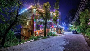 Um hotel com design moderno, destacando uma entrada imponente e fachada bem iluminada.