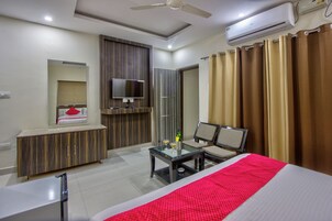 A modern hotel room with a bed, a TV, a desk, and a chair.