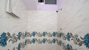 Une salle de bain aux carreaux de marbre blanc ornés de motifs floraux.