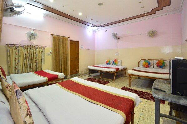 A hotel room with three beds, a television, and ceiling fans. - Hotel Jai Maa Palace (Jaipur)