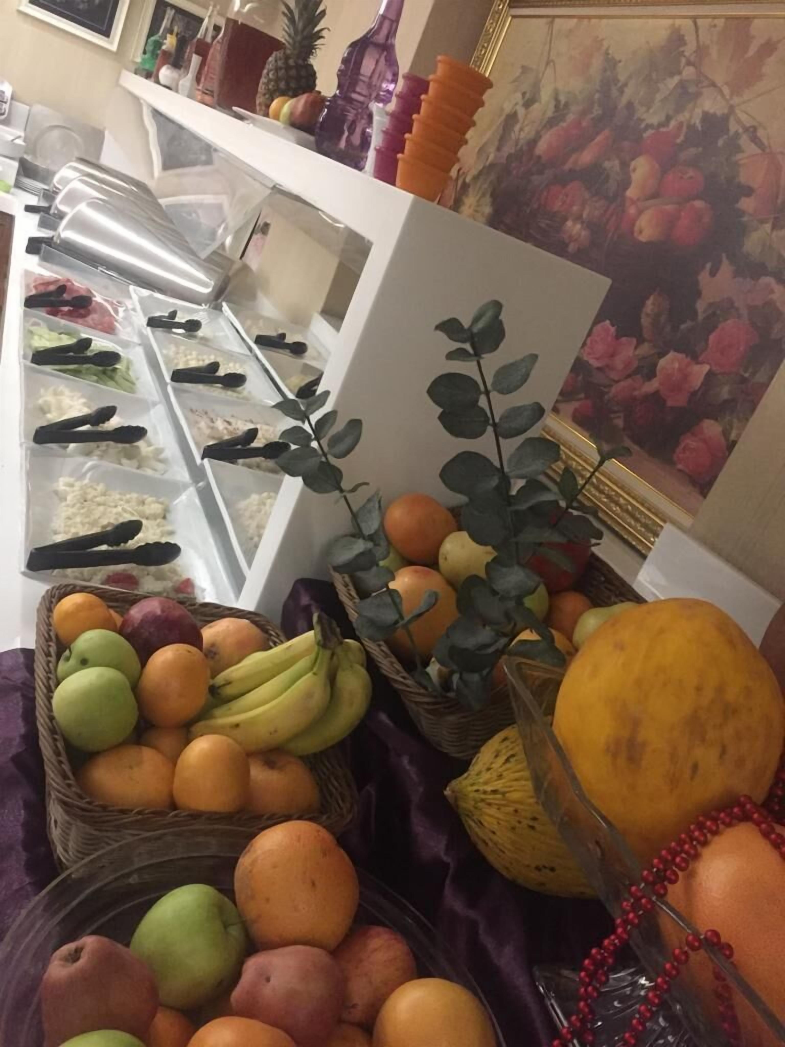 Ein Buffetbereich mit verschiedenen Früchten und Gemüsesorten, präsentiert in Körben und Behältern.