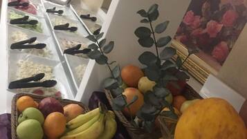 Ein Buffetbereich mit verschiedenen Früchten und Gemüsesorten, präsentiert in Körben und Behältern.