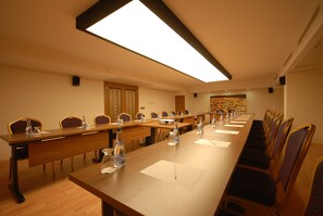 A conference room with a long table, chairs, and a ceiling light.