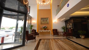 A lobby with a chandelier, seating area, and a view of the street through a glass door. - Imamoglu Pasa Hotel - Boutique Class (Kocasinan)
