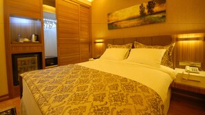 A hotel room with a large bed, wooden wardrobe, bedside table with a lamp, and a painting on the wall. - Imamoglu Pasa Hotel - Boutique Class (Kocasinan)