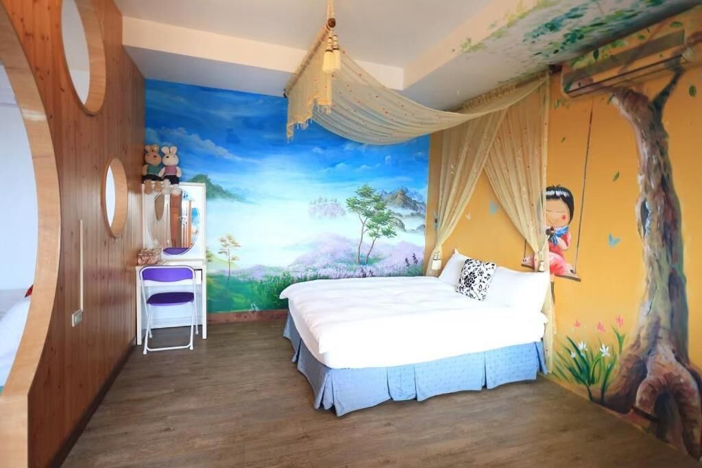 A bedroom with a bed, a chair, a wardrobe, and a mural on the wall.