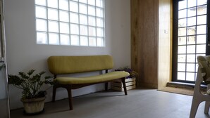 Une pièce avec un banc en bois, une plante en pot et une vue par la fenêtre.