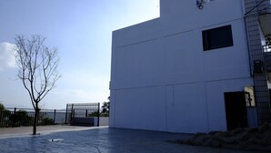 Un bâtiment moderne à la façade plate, doté d’une petite fenêtre et d’un réservoir d’eau sur le toit.