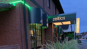 A building with a sign reading "zeitlos" and a brick facade. - zeitlos -  Hotel & Restaurant am Fuchsbach (Pattensen)
