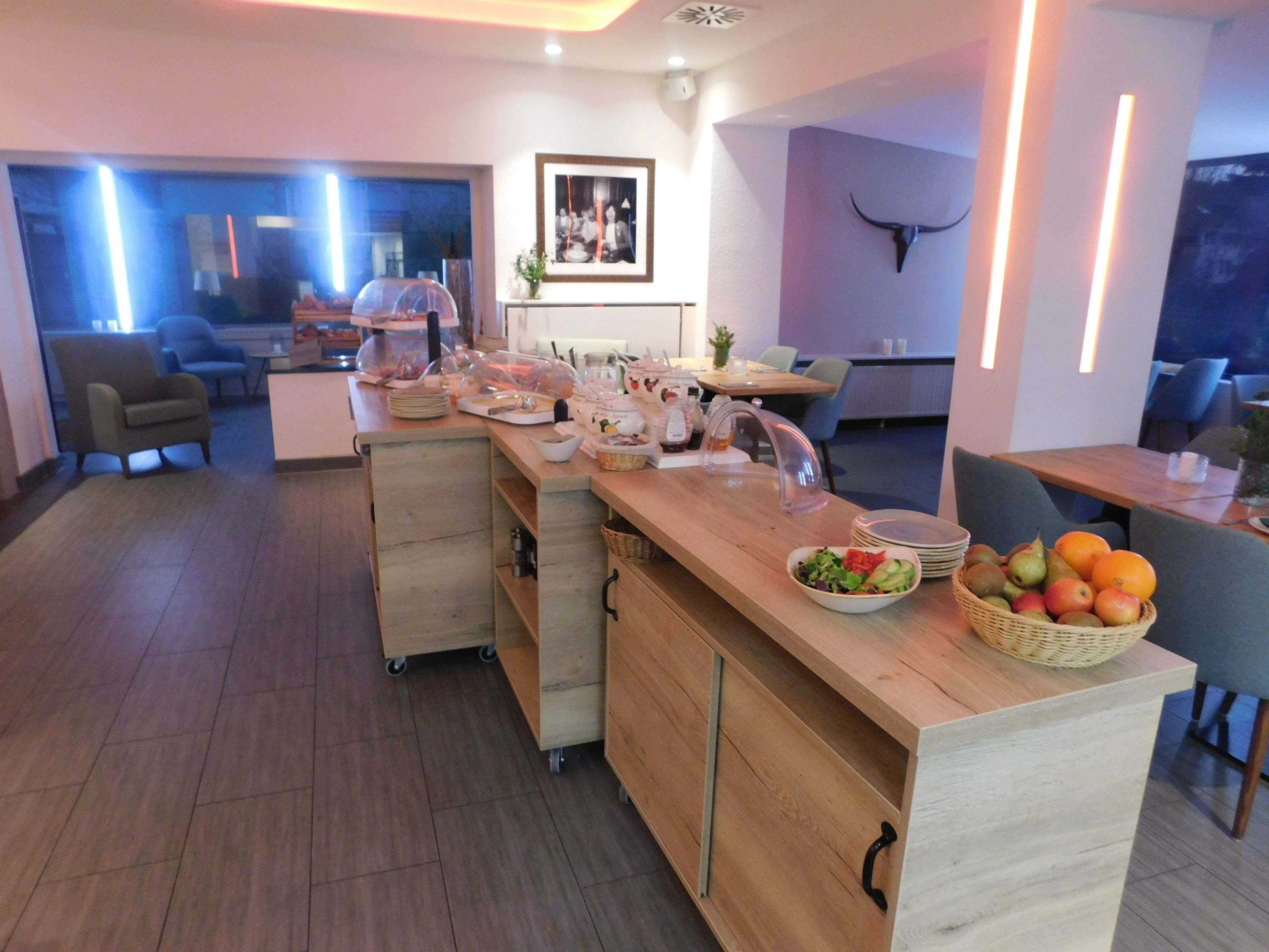 A modern kitchen with a wooden island, a dining area with chairs, and a bull head decoration on the wall.