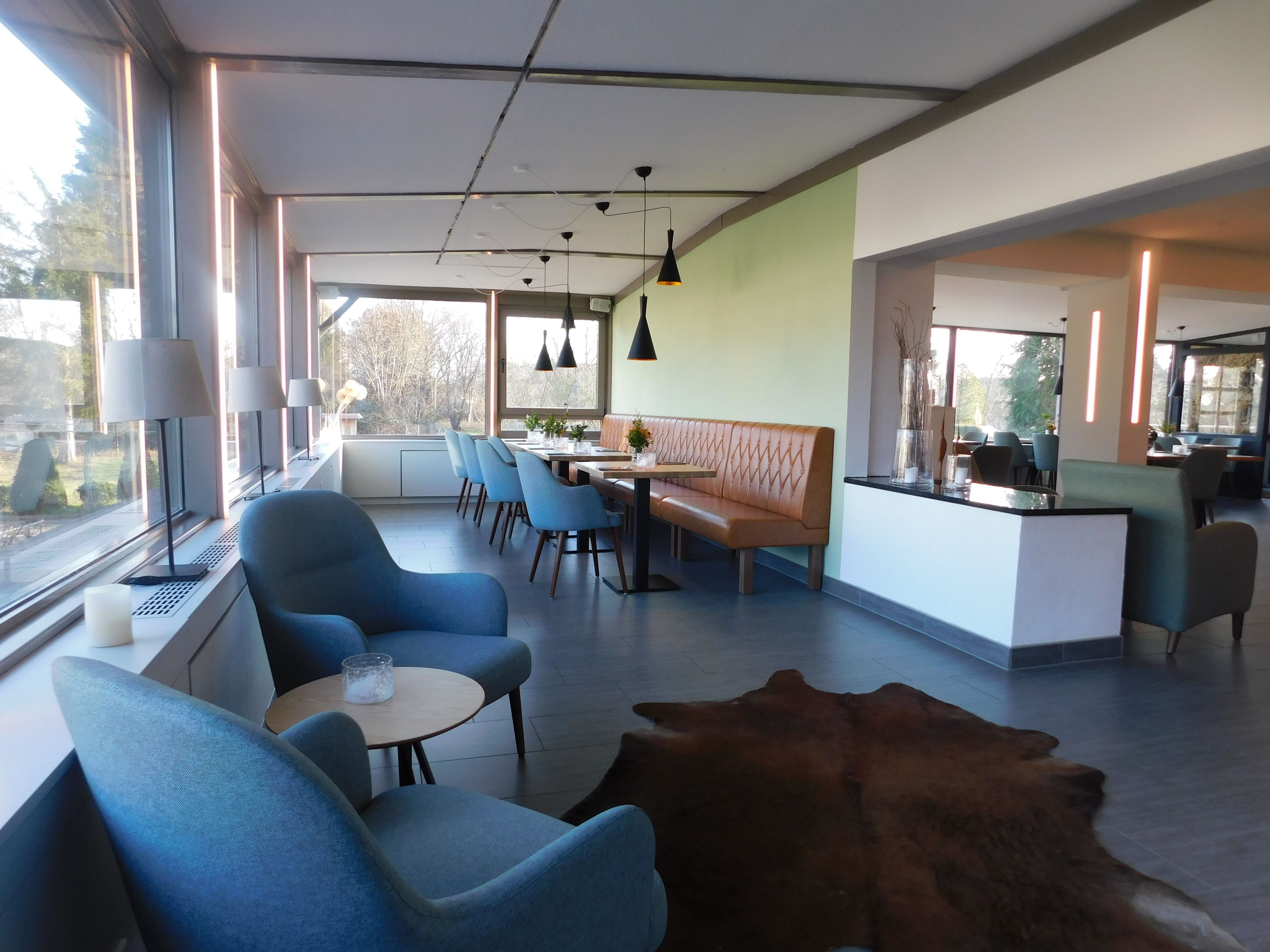 A modern interior with a seating area, a dining table, and a bar.